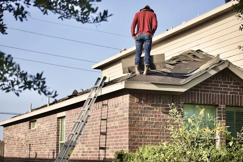 Professional roofer working on a residential roof in West Village